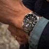 Seiko SRPK29K1 – 5 Sports SKX sat na ruci muškarca, sa crnim brojčanikom i srebrnom narukvicom, savršen za svakodnevno nošenje i poslovne prilike