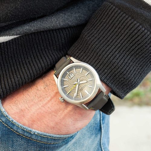Seiko SUR543P1 – Seiko Classic sat na ruci muškarca, sa sivim brojčanikom i sivoj najlonskoj narukvici, savršen za poslovne prilike ili svakodnevno nošenje