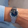 Seiko SRPK87K1 5 Sports SNXS muški sat u srebrnoj boji na ruci muškarca, prikazujući njegov elegantan dizajn sa plavim brojčanikom i čeličnom narukvicom. Savršen za svakodnevno nošenje i poslovne prilike.