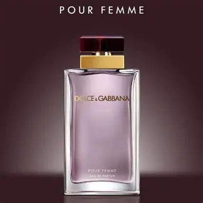 Detalj zlatnog poklopca i staklene bočice Dolce & Gabbana Pour Femme EDP na misticnoj pozadini