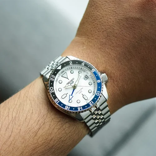 Detalj Seiko 5 Sport SSK033K1 GMT muškog ručnog sata sa crnim brojčanikom, plavim GMT indikatorom i metalnim kućištem. Sat s automatskim mehanizmom i lako čitljivim numeričkim prikazom na ruci muskarca