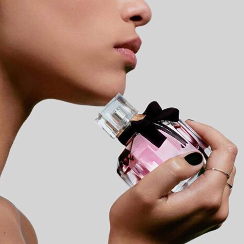 YSL Mon Paris ženski parfem – romantičan, moderan i nežan miris prikazan u pariskom, elegantnom ambijentu koji naglašava ženstvenost i zavodljivost. Zena drzi parfem u ruci