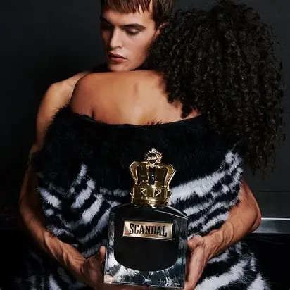 JPG Scandal Le. Parfum toptaurus.rs Scandal Le Parfum muški parfem – intenzivan, moćan i luksuzan miris prikazan u elegantnom večernjem ambijentu koji naglašava muževnost i samopouzdanje. Momak grli devojku i drzi bocicu parfema