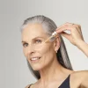 Starija žena koristi Estée Lauder Advanced Night Repair Serum u noćnoj rutini nege kože