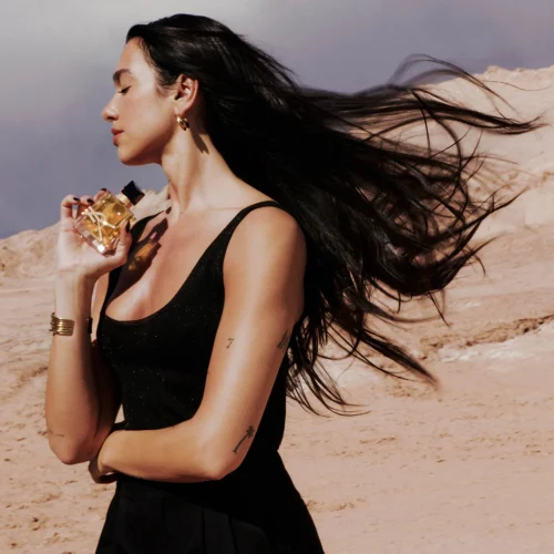 YSL Libre ženski parfem – moderan, moćan i sofisticiran miris prikazan u elegantnom urbanom ambijentu koji naglašava samopouzdanje i ženstvenost. Zena na slobodi drzi parfem, kosu joj nosi vetar