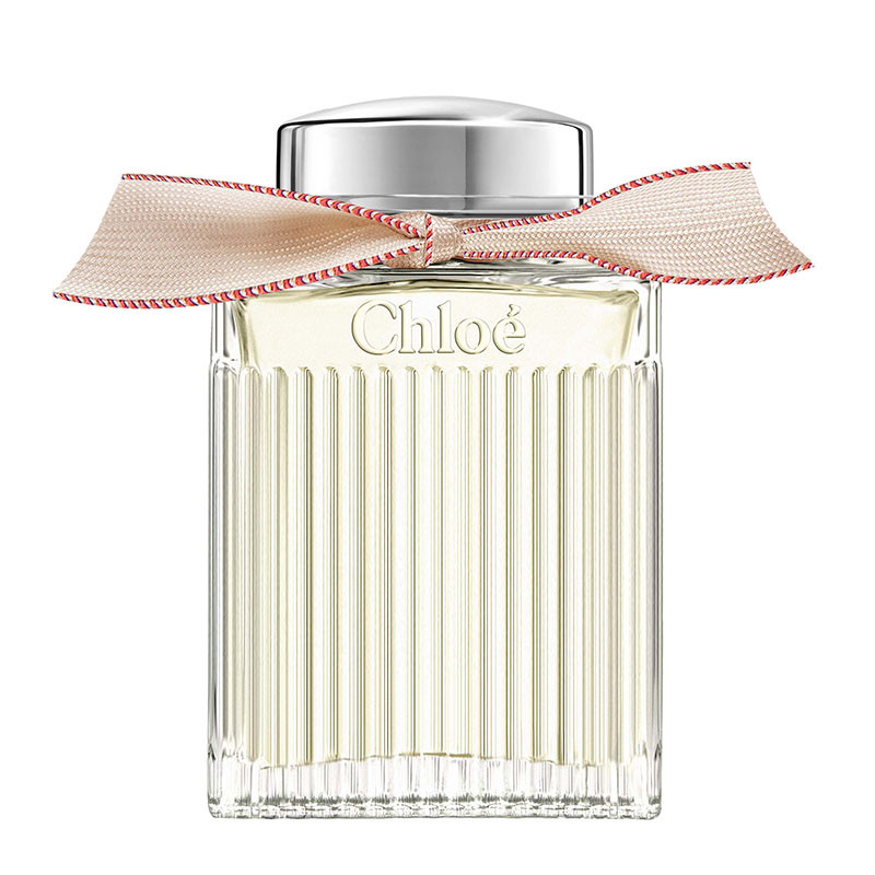 Bočica parfema Chloé Lumineuse sa prozirnim staklom, vintage stilom i ručno vezanom vrpcom oko vrata bočice.