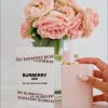 Burberry Her Intense EDP zenski parfem pakovanje i bocica u ruci zene pored vaze sa cvecem
