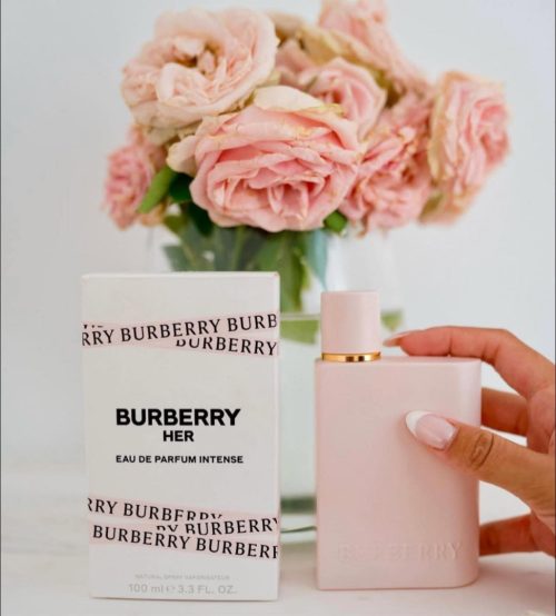 Burberry Her Intense EDP zenski parfem pakovanje i bocica u ruci zene pored vaze sa cvecem