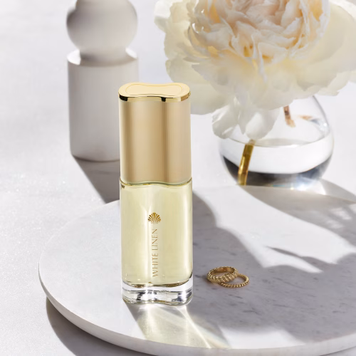 Estee Lauder White Linen EDP zenski parfem toptaurus.rs 1 White Linen EDP elegantna bočica ženskog parfema u elegantnoj sobi sa cvecem